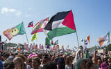 The flag of Palestine is waved in a crowd of festivalgoers at the hip hop trio Kneecap's performance during the Glastonbury Festival in Worthy Farm, Somerset, England, June 28, 2025. (Scott A Garfitt/Invision/AP)