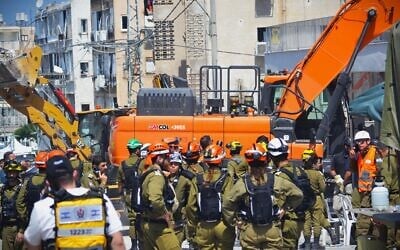 Rescue teams work to recover missing persons in a destroyed Bat Yam building following a deadly Iranian missile attack, June 15, 2025. (Stav Levaton/Times of Israel)