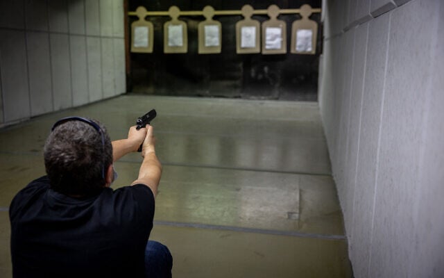 Illustrative: A man practices shooting a handgun at a Jerusalem shooting range, April 3, 2022 (Yonatan Sindel/Flash90)