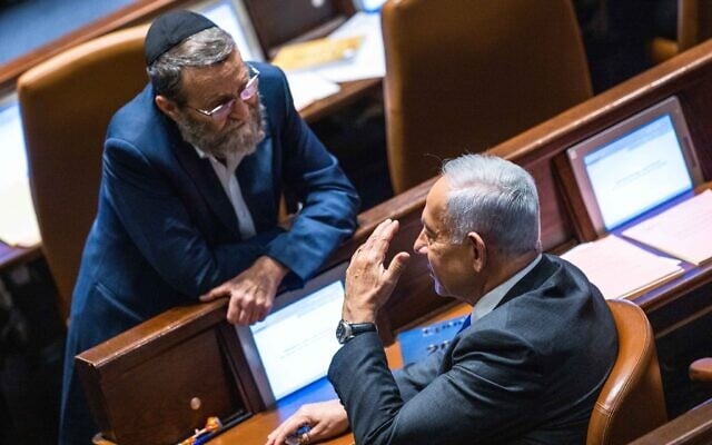 File: Likud leader MK Benjamin Netanyahu (sitting) with MK Moshe Gafni  at a vote in the assembly hall of the Knesset in Jerusalem, on December 28, 2022 (Olivier Fitoussi/Flash90)