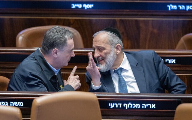 Defense Minister Israel Katz (left) and Shas chairman Aryeh Deri speak in the Knesset, December 31, 2024. (Chaim Goldberg/Flash90)