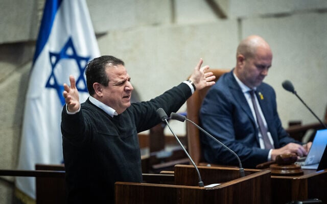 MK Ayman Odeh speaks during a plenum session at the assembly hall of the Knesset in Jerusalem, on January 27, 2025. Knesset Speaker Amir Ohana is seated in the background. (Chaim Goldberg/Flash90) MK Ayman Odeh speaks during a plenum session at the assembly hall of the Knesset in Jerusalem, on January 27, 2025. Knesset Speaker Amir Ohana is seated in the background. (Chaim Goldberg/Flash90)