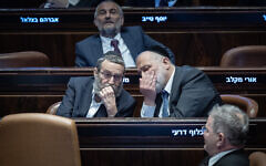 Shas party leader MK Aryeh Deri, right, speaks with United Torah Judaism No. 2 MK Moshe Gafni during a Knesset plenum session in Jerusalem, February 10, 2025. (Yonatan Sindel/Flash90)