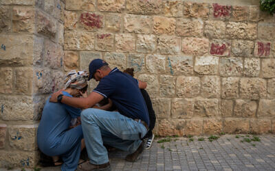 Israelis take cover in Jerusalem as sirens warn of an incoming missile fired from Yemen, June 1, 2025. (Chaim Goldberg/Flash90)