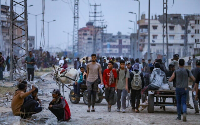 Palestinians walking near an aid distribution point in the Netzarim Corridor in the central Gaza Strip on June 9, 2025. (Ali Hassan/Flash90)