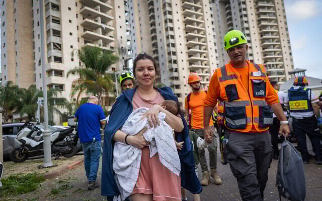 Israeli security and rescue forces at the scene where a ballistic missile fired from Iran hit and caused damage in Petah Tikva, June 16, 2025. (Chaim Goldberg/Flash90)