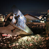 A soldier stands next to a remnant of an Iranian missile in the city of Safed on June 16, 2025. (David Cohen/Flash90)