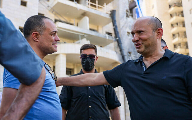Former prime minister Naftali Bennett visits the site where a ballistic missile fired from Iran hit in Petah Tikva, June 18, 2025. (Jonatha Shaul/Flash90)