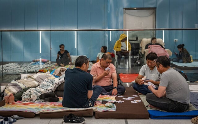 A group of men play cards as they take shelter from Iranian missile attacks in an underground light rail station in central Israel, June 19, 2025. (Chaim Goldberg/Flash90) A group of men play cards as they take shelter from Iranian missile attacks in an underground light rail station in central Israel, June 19, 2025. (Chaim Goldberg/Flash90)