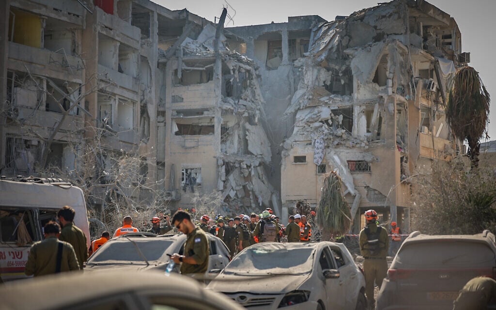 Security and rescue forces at the scene of an Iranian ballistic missile strike in Holon, June 19, 2025 (Oren Ben Hakoon/Flash90)