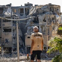 A man looks at a building in Holon damaged by a ballistic missile fired from Iran on June 19, 2025. (Oren Ben Hakoon/Flash90)