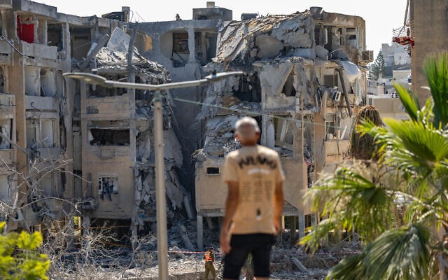 A man looks at a building in Holon damaged by a ballistic missile fired from Iran on June 19, 2025. (Oren Ben Hakoon/Flash90)