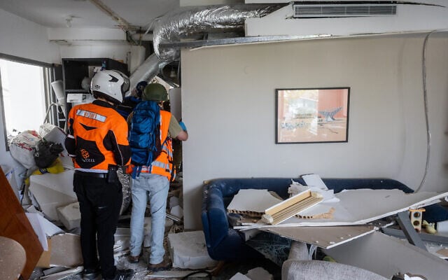 Israeli security and rescue forces at the scene where a ballistic missile fired from Iran hit and caused damage in Tel Aviv, June 22, 2025. (Chaim Goldberg/Flash90)