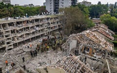 Israeli security and rescue forces at the scene where a ballistic missile fired from Iran hit and caused damage in Tel Aviv, June 22, 2025. (Chaim Goldberg/Flash90)