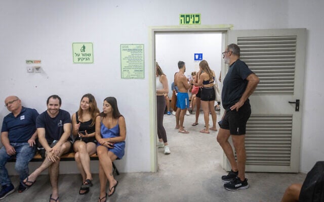 Israelis take cover in a public shelter in Tel Aviv as a siren warns of incoming ballistic missiles fired from Iran on June 23, 2025. (Chaim Goldberg/FLASH90)