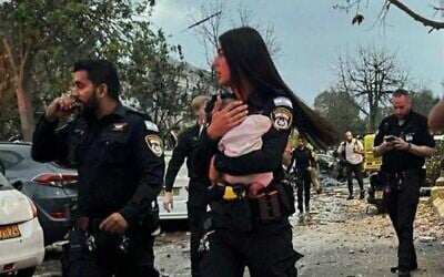 A police officer holds a three-month-old baby after it was pulled from the ruins of a home hit by an Iranian missile in Rishon Letzion on June 14, 2025 (Israel Police)