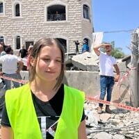 Doaa Hmade, volunteer with the Home Front Command and Tamra municipality, stands on the street in Tamra where a Iranian ballistics missile struck a house, killing four women on June 15, 2025. (Diana Bletter/Times of Israel)