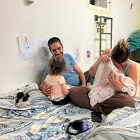 Hagar Amor, right, nurses her baby while her husband, Tal, sits with their daughter Gaia in a public shelter in Shavei Zion on June 17, 2025 (Diana Bletter/Times of Israel)