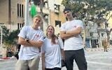 Lev Echad volunteers (from left) Ray Margolin, May Esher, and Eyal Meidan, stand against a background of buildings damaged by an Iranian missile on June 22, 2025. (Sue Surkes/Times of Israel)