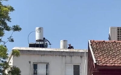 A man suspected of murdering his 80-year-old mother barricades himself on the roof of an apartment building in Rehovot on June 12, 2025. (Screenshot/Ynet)