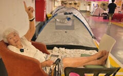 A Tel Aviv resident shelters in a parking lot under Dizengoff Center, Tel Aviv, in an area organized by the Brothers and Sisters in Arms movement, June 16, 2025. (Eli Katzoff/ToI)