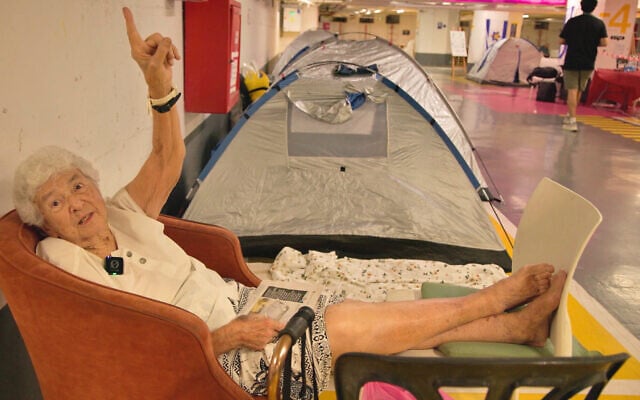 A Tel Aviv resident shelters in a parking lot under Dizengoff Center, Tel Aviv, in an area organized by the Brothers and Sisters in Arms movement, June 16, 2025. (Eli Katzoff/ToI)
