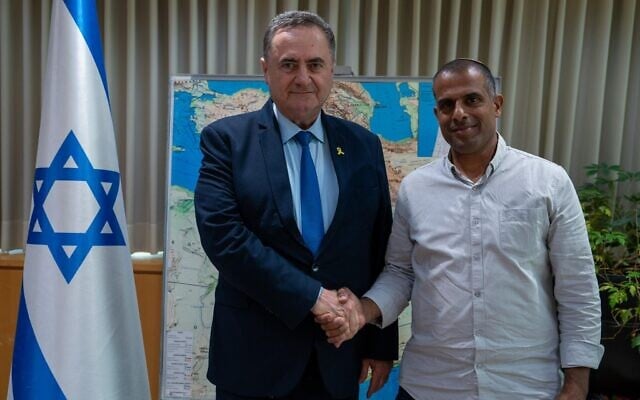 Defense Minister Israel Katz, left, shakes hands with Col. (res.) Avichai Tanami, the new czar to handle extremist settlers in the West Bank, June 3, 2025. (Ariel Hermoni/Defense Ministry)