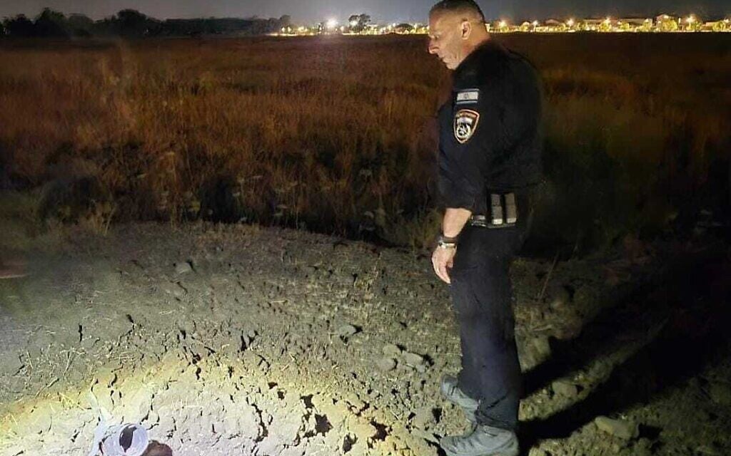 A police officer at the site of a rocket impact near the Golan Heights community of Ramat Magshimim, shortly after two rockets were fired from Syria, June 3, 2025. (Israel Police)
