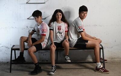 Hapoel Jerusalem soccer club fans model new 'away' uniforms in a bomb shelter, in a sign of the times, on June 17, 2025 (Courtesy)