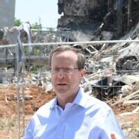 President Isaac Herzog visits the site of an Iranian missile strike in Petah Tikva on June 16, 2025. (Haim Zach / GPO)