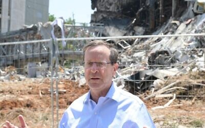 President Isaac Herzog visits the site of an Iranian missile strike in Petah Tikva on June 16, 2025. (Haim Zach / GPO)