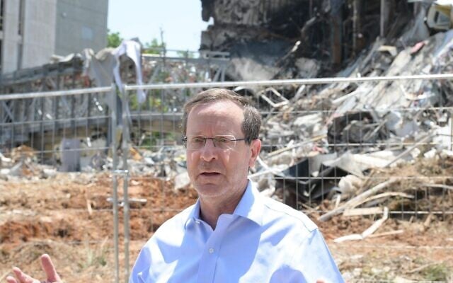 President Isaac Herzog visits the site of an Iranian missile strike in Petah Tikva on June 16, 2025. (Haim Zach / GPO)