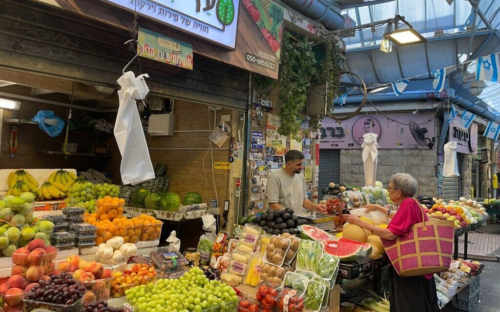 Shoppers buying groceries at the Mahane Yehuda Market during the war with Iran on June 17, 2025. (Rossella Tercatin/Times of Israel)