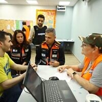Ramat Gan mayor Carmel Shama-Hacohen (second from right), deputy mayor Einav Bar Cohen (second from left) and a social worker from the Ramat Gan Municipality speak with a resident at a first aid center established within an hour of an Iranian missile attack on the night between June 13 and 14, 2025. (Ori Habushi)