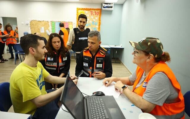 Ramat Gan mayor Carmel Shama-Hacohen (second from right), deputy mayor Einav Bar Cohen (second from left) and a social worker from the Ramat Gan Municipality speak with a resident at a first aid center established within an hour of an Iranian missile attack on the night between June 13 and 14, 2025. (Ori Habushi)