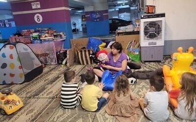 Bibliotherapist and puppeteer Esti Osovsky volunteers for Brothers and Sisters in Israel in an underground parking structure-turned public shelter that the organization helped to equip in the central city of Rishon Lezion, June 23, 2025. (Brothers and Sisters in Israel)