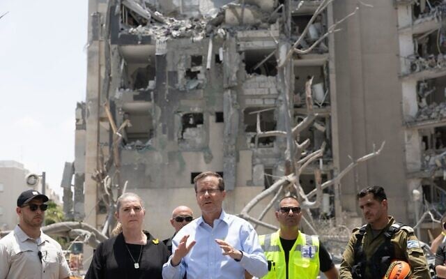President Isaac Herzog (C) and his wife Michal at the scene of a ballistic missile strike in Beersheba on June 24, 2025 (Avi Kaner/GPO)