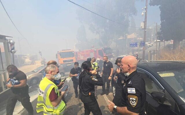 Police evacuate residents from the scene of a developing wildfire in Haifa's Halisa neighborhood on June 29, 2025. (Israel Police) Police evacuate residents from the scene of a developing wildfire in Haifa's Halisa neighborhood on June 29, 2025. (Israel Police)