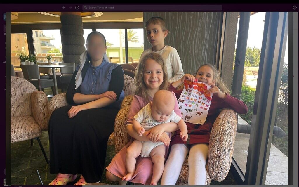 Part of the Rotstein family at a hotel in the northern city of Haifa after their apartment was destroyed in an Iranian missile attack on the northern city of Haifa on June 15, 2025, photographed on June 16, 2025. Yehudit Rotstein (left) asked for her face to be blurred. (Sue Surkes/Times of Israel)