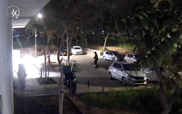Prior to chucking a grenade at a residential building in Tel Aviv, a masked suspect is seen at the scene in March 2025. (Screenshot/Israel Police)