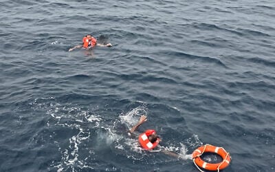 Crew members said to be from cargo ship Eternity C, which sank after being attacked, are seen at sea during a rescue operation, off Yemen, in this handout image released on July 9, 2025. (Diaplous/Handout via REUTERS)