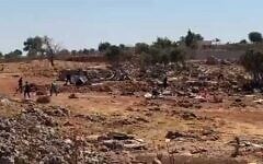 Settlers hurl stones, reportedly during clashes with Palestinians in the West Bank town of Sinjil on July 11, 2025. (Screen capture: Al-Jarmaq News)
