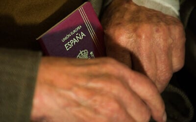 ILLUSTRATIVE: Man holds Spanish passport, June 9, 2009. (LEON NEAL / AFP)