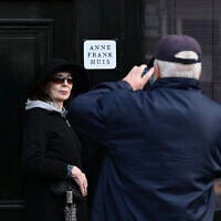 A man takes a picture of a woman in front of the Anne Frank House museum in Amsterdam, on April 4, 2024. (JOHN THYS / AFP)