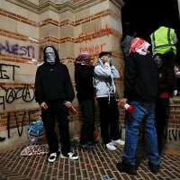 Protesters inside an encampment set up by pro-Palestinian students and activists wrap scarves on their faces as they demonstrate on the campus of the University of California, Los Angeles (UCLA) in Los Angeles, California, on May 1, 2024. (Etienne LAURENT / AFP)