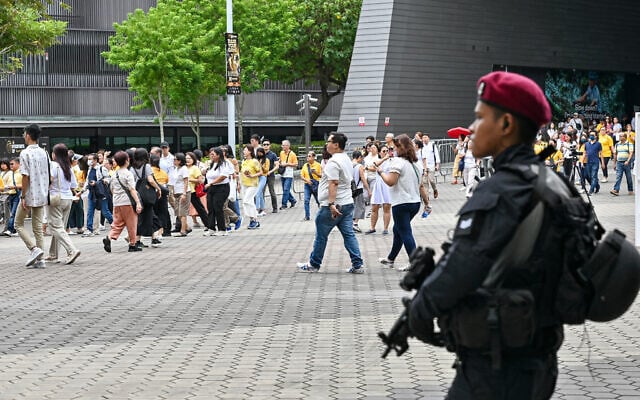 Illustrative: An armed police officer stands guard as Catholic faithful arrive ahead of a mass by Pope Francis at the National Stadium in Singapore on September 12, 2024. (Roslan RAHMAN / AFP)