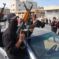 Members of Hamas's armed wing, the Ezzedine al-Qassam Brigades, take part in a military parade along a street in Deir al-Balah, in the central Gaza Strip, on January 19, 2025. (BASHAR TALEB / AFP)