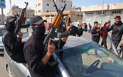 Members of Hamas's armed wing, the Ezzedine al-Qassam Brigades, take part in a military parade along a street in Deir al-Balah, in the central Gaza Strip, on January 19, 2025. (BASHAR TALEB / AFP)