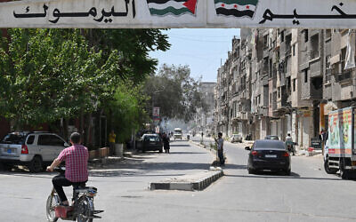 A man rides a motorbike at the entrance of the Yarmuk camp for Palestinian refugees and their descendants in southern Damascus on May 22, 2025. (LOUAI BESHARA / AFP)