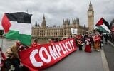 Illustrative: Protesters wave Palestinians flags and a banner reading 'Complicit' as they gather on Westminster Bridge in front of 'Big Ben,' at the Palace of Westminster, home to the Houses of Parliament, in central London, on June 4, 2025. (Adrian Dennis / AFP)